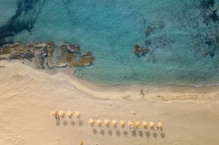 Kreta: Eine Luftaufnahme eines Sandstrands mit ein paar Felsen mit türkisem, glasklarem Wasser