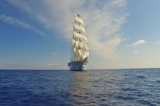 Ein 4-Master Segelschiff ragt imposant auf dem tiefblauen Meer hervor.