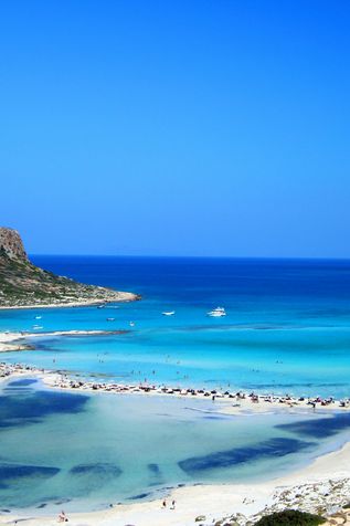 Kreta: Ein weißer, zerklüfteter Sandstrand an Felsen mit türkisem Wasser