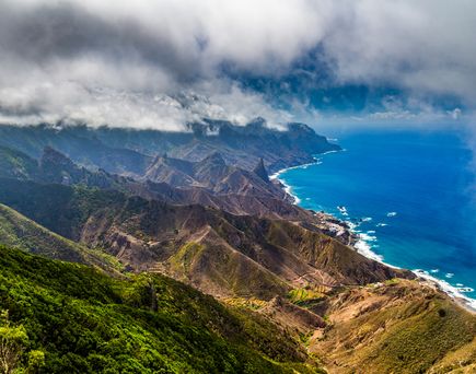 Teneriffa im Januar: Eine Luftaufnahme auf eine grüne Berglandschaft direkt am blauen Meer