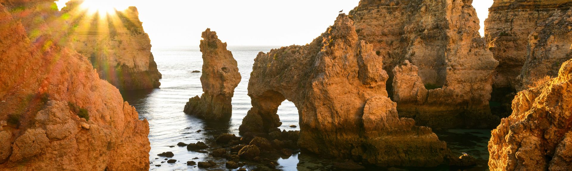 Skurrile Felsformationen im Wasser mit untergehender Sonne