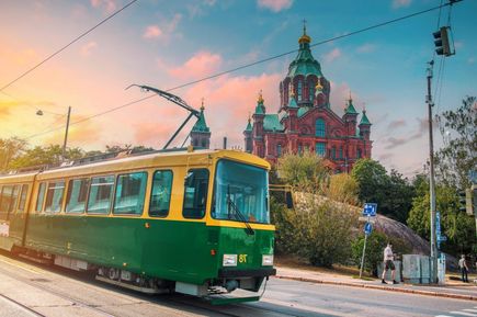 Eine bunte Straßenbahn fährt durch eine Altstadt.