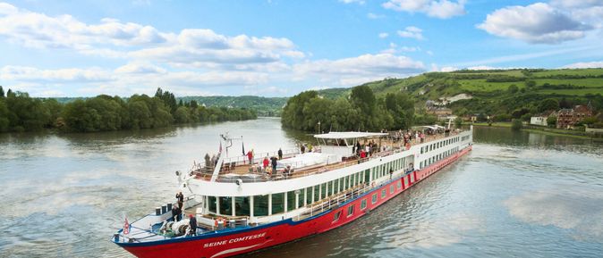 Romantik: ein Flusskreuzfahrtschiff der Reederei nicko Cruises auf dem Fluss Seine umgeben von grüner Landschaft