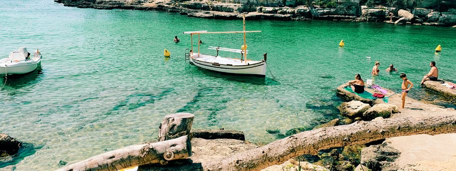 Urlaub mit Kindern: Eine Bucht mit türkis-grünem Wasser und ein paar Booten