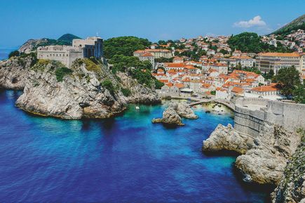 Urlaub in Osteuropa: Eine felsige Bucht mit mediterranen Häusern mit orangenen Dächern in Koratien