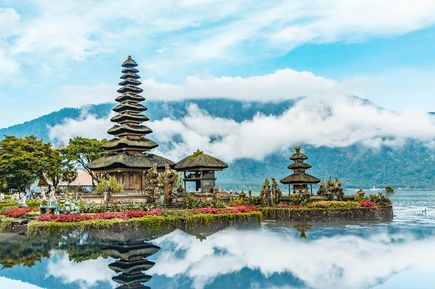 Ein balinesicher Tempel auf einem See im Hintegrund ein Berg auf Bali