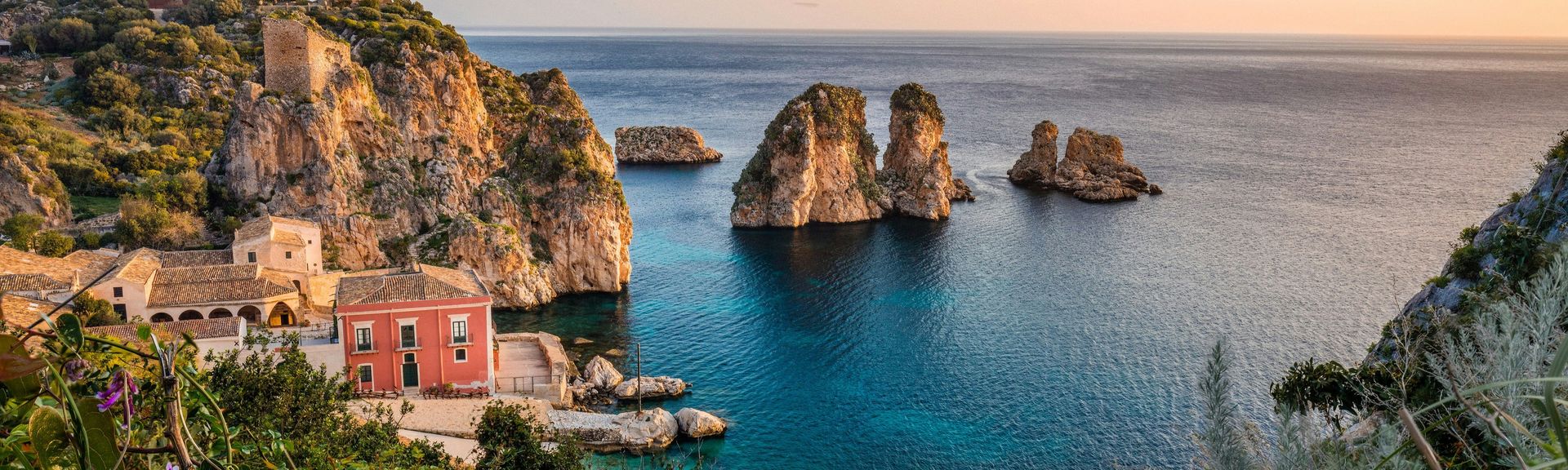 Italien Urlaub: Eine ruhige Bucht zwischen Felsen und mediterrane Häuser