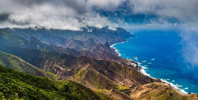 Resturlaub: Eine grüne Berglandschaft grenzt ans tiefblaue Meer