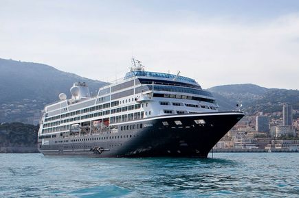 Das Schiff Amazara Onward der Reederei Azamara auf dem hellblauen Meer in Hafennähe