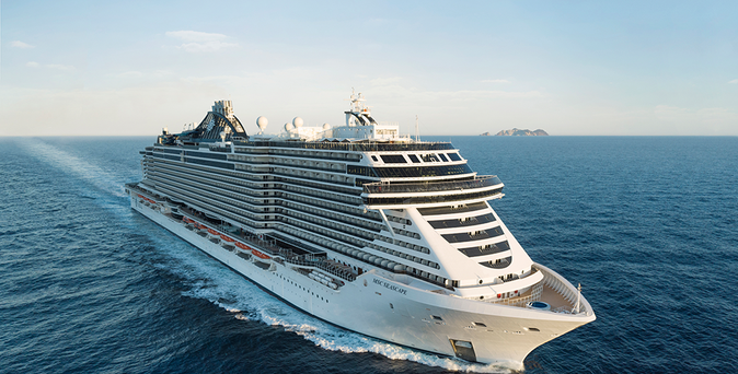 Ein riesiges, weißes Kreuzfahrtschiff der Reederei MSC Cruises gleitet auf tiefblauem Meer dahin.