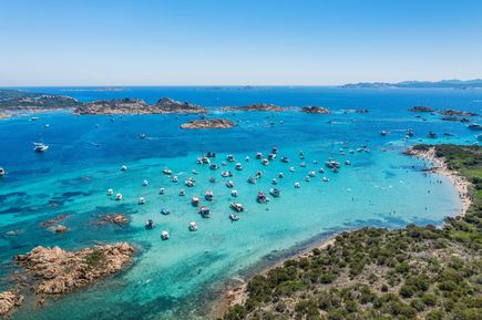 Kreuzfahrten 2026: Eine mediterrane Bucht mit türkisem Wasser und vielen Booten