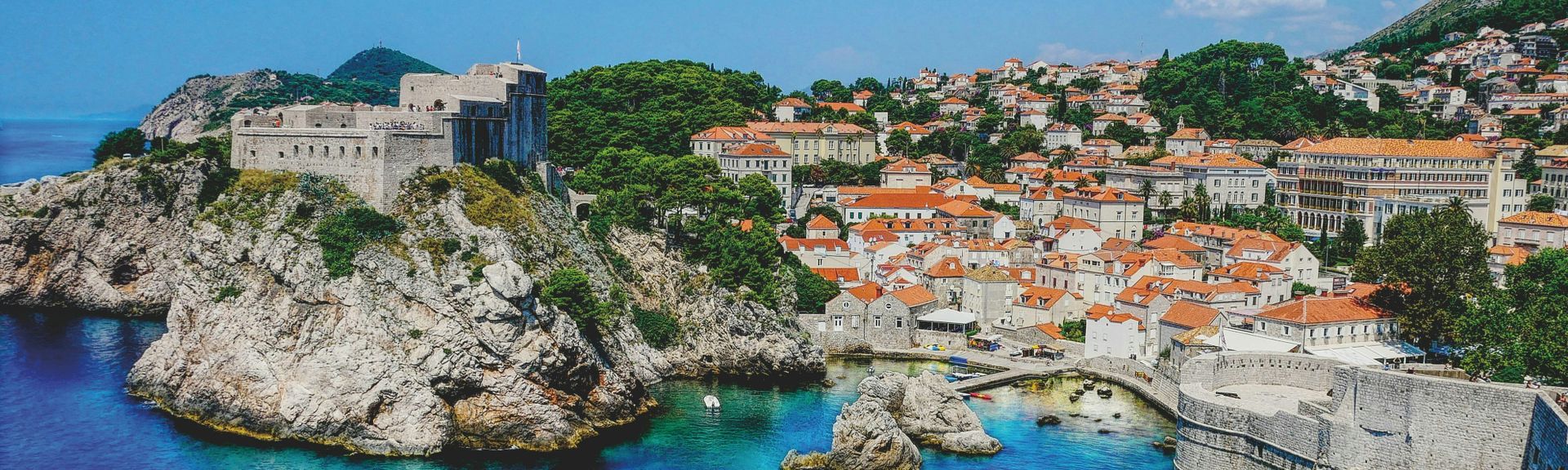 Kroatien Urlaub: Eine mediterrane Bucht, mit Steinfelsen und Steinhäusern mit orangenen Dächern