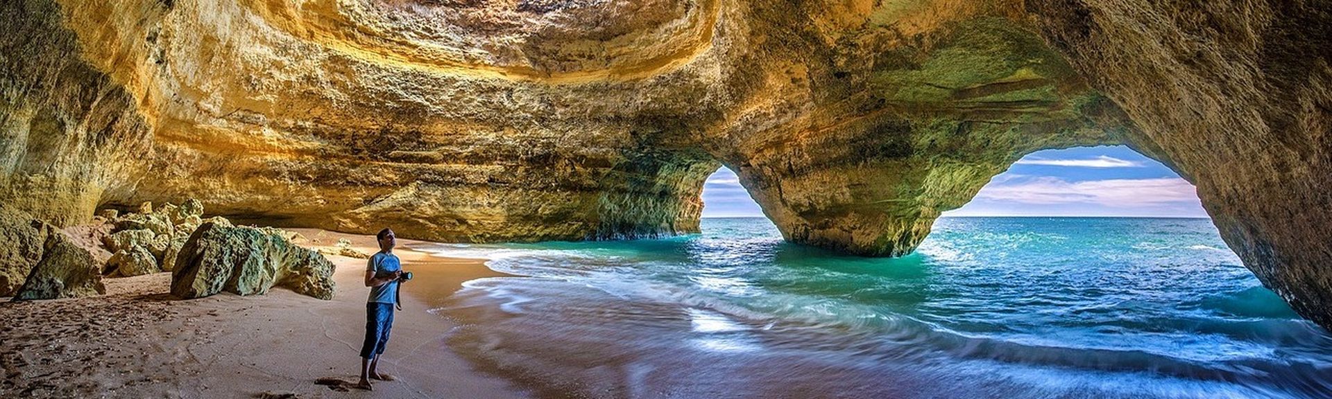 RIB Tipp Algarve: Ein Mann steht unter einer skurrilen Felsformation an der portugiesischen Algarve