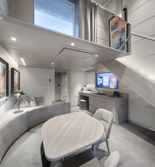 Das Wohnzimmer einer mehrstöckigen Suite auf einem Schiff im Tarif MSC Yacht Club