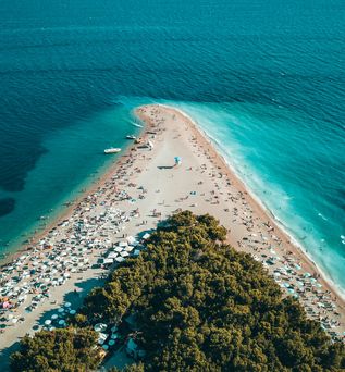 Kroatien Urlaub: Eine Luftaufnahme einer spitz zulaufenden Bucht mit türkis-blauem Wasser.